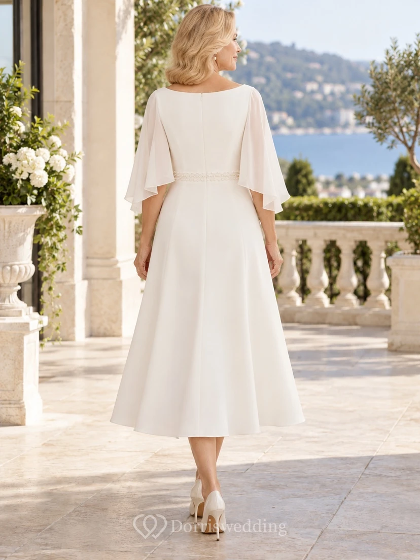 Vestido de novia de corte barco hasta la rodilla para novias mayores con cintura adornada con cuentas y mangas tipo media capa. view 2