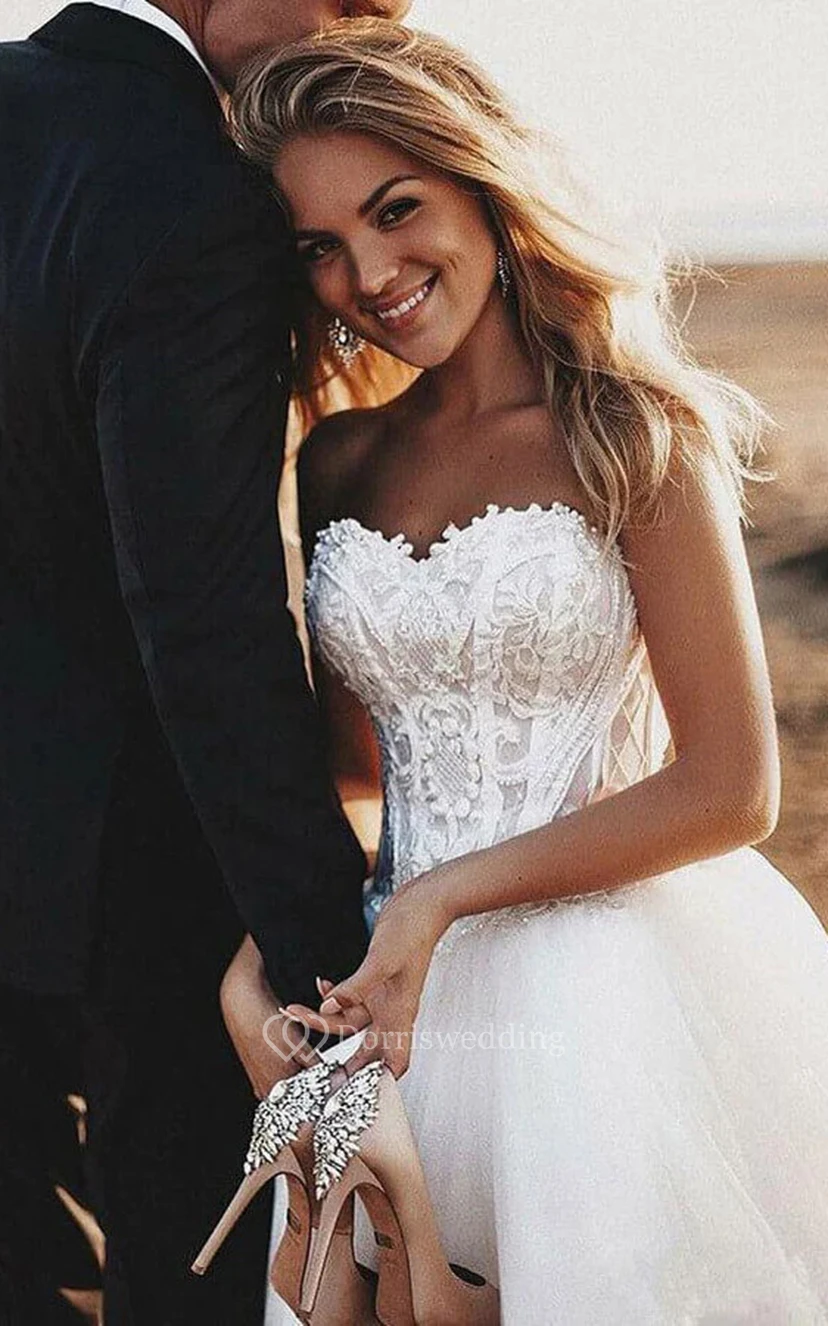 Elegantes A-Linien-Brautkleid aus Tüll mit Schnürung, Spitzenoberteil und kurzer Schleppe für die Strandhochzeit. view 3