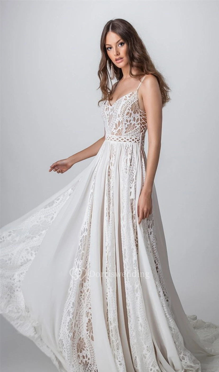 Robe de mariée d'été bohème à bretelles spaghetti et plis empire, dos nu plongeant, en dentelle et style bohème, idéale pour les mariages en extérieur.