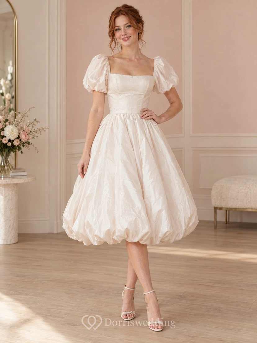 Robe de mariée mi-longue à col carré, manches bouffantes et ourlet froncé