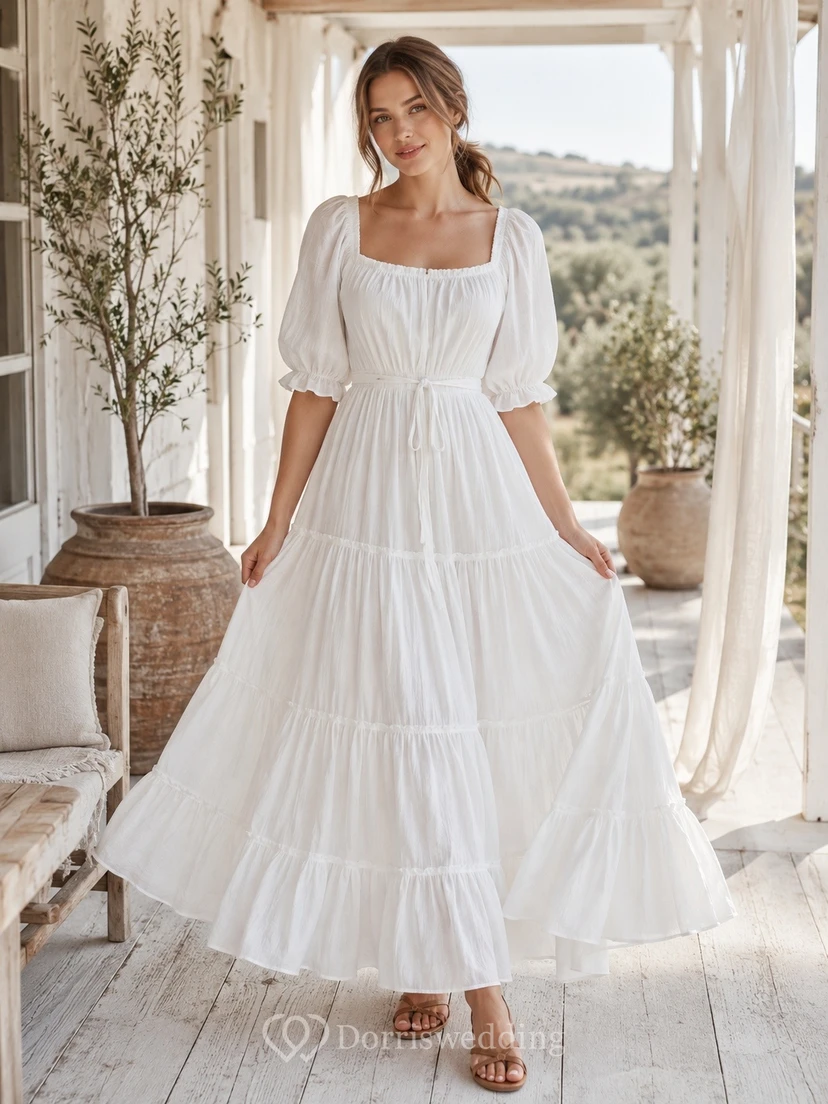 Vestido blanco de gasa con escote cuadrado, manga corta, corte en A y largo hasta los tobillos con volantes.