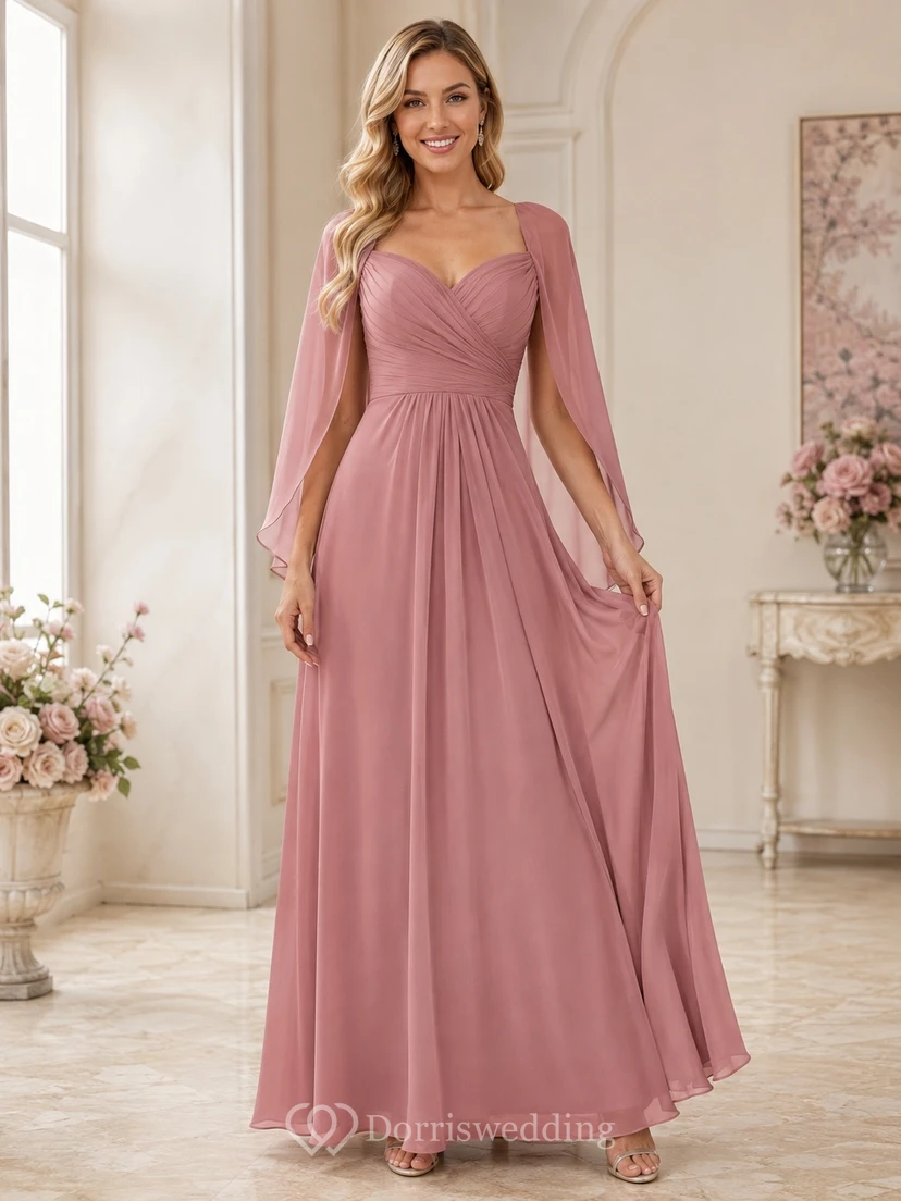 Robe de demoiselle d'honneur élégante en mousseline rose poudré, décolleté cœur, manches cape, longueur au sol, idéale pour une réception.