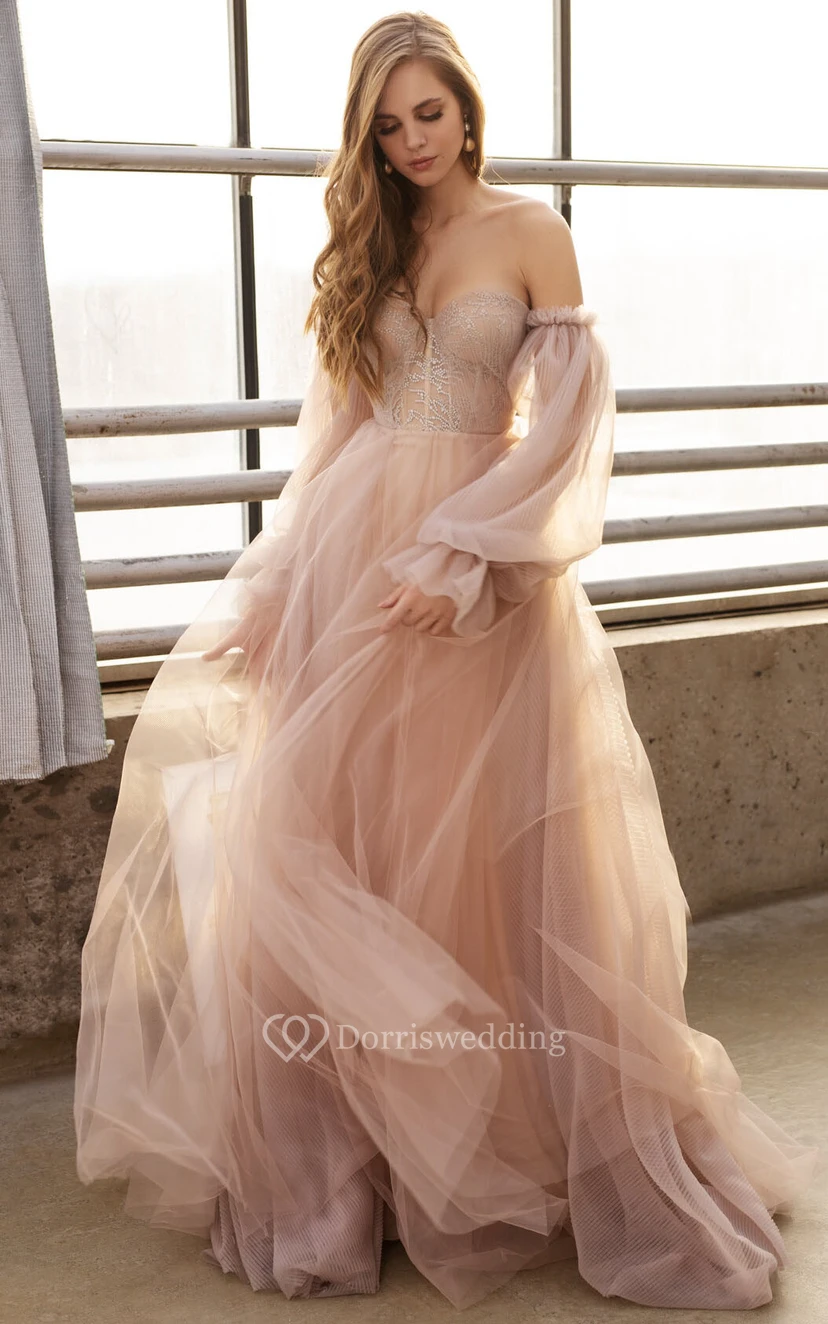Robe de mariée bohème en tulle rose poudré fluide à manches longues bouffantes et décolleté en cœur, ornée d'un haut perlé