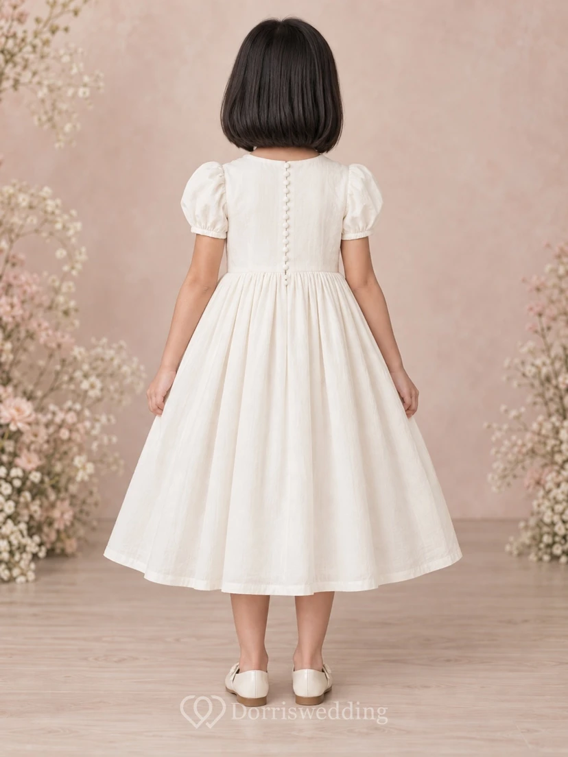 Schlichtes, schlichtes, wadenlanges, elfenbeinfarbenes Blumenmädchenkleid mit kurzen Puffärmeln, Muschelsaum, Spitzenborte, Abnähern, Raffungen und Knopfleiste am Rücken. view 2