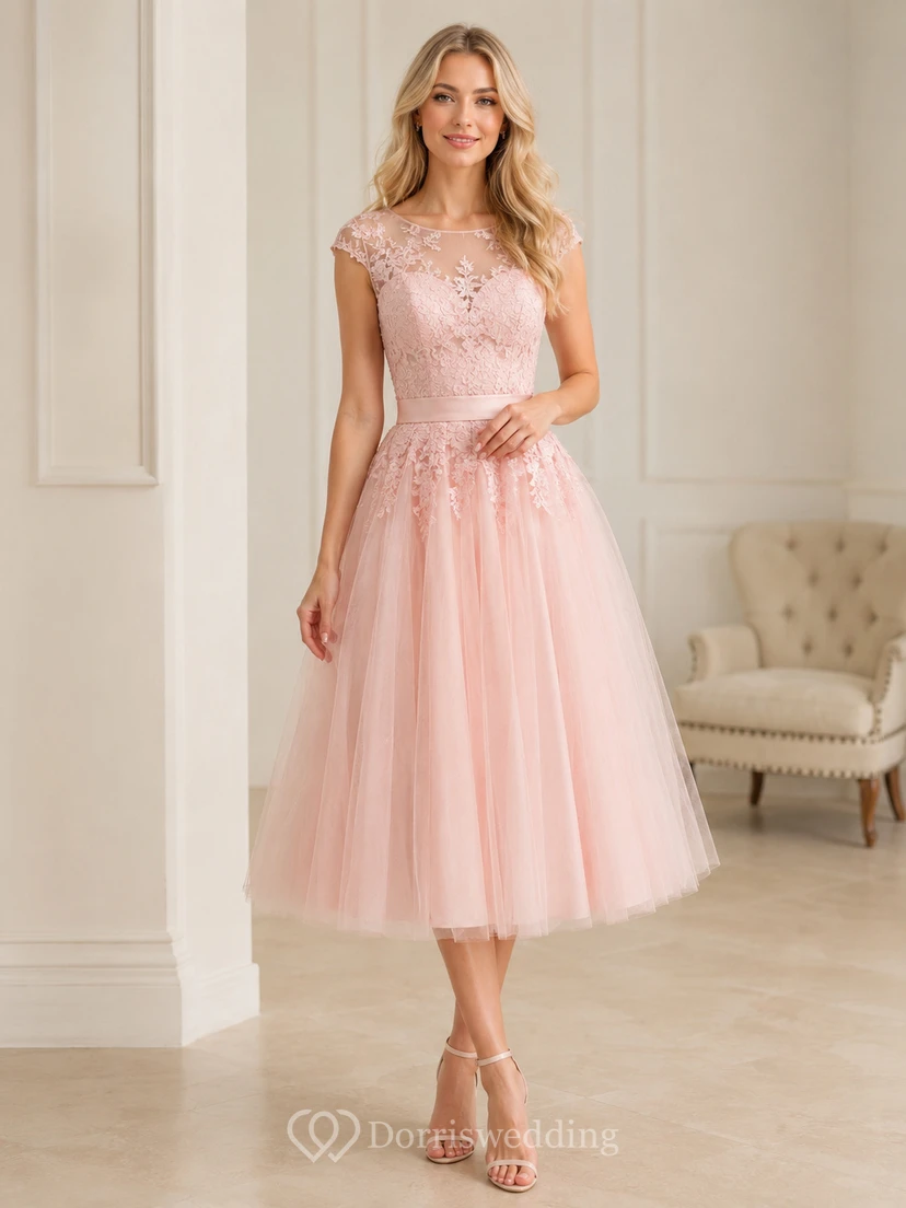 Vestido de invitada de corte A, largo midi, con escote barco, manga corta, tul, encaje, pedrería, efecto ilusión y cremallera en la espalda.