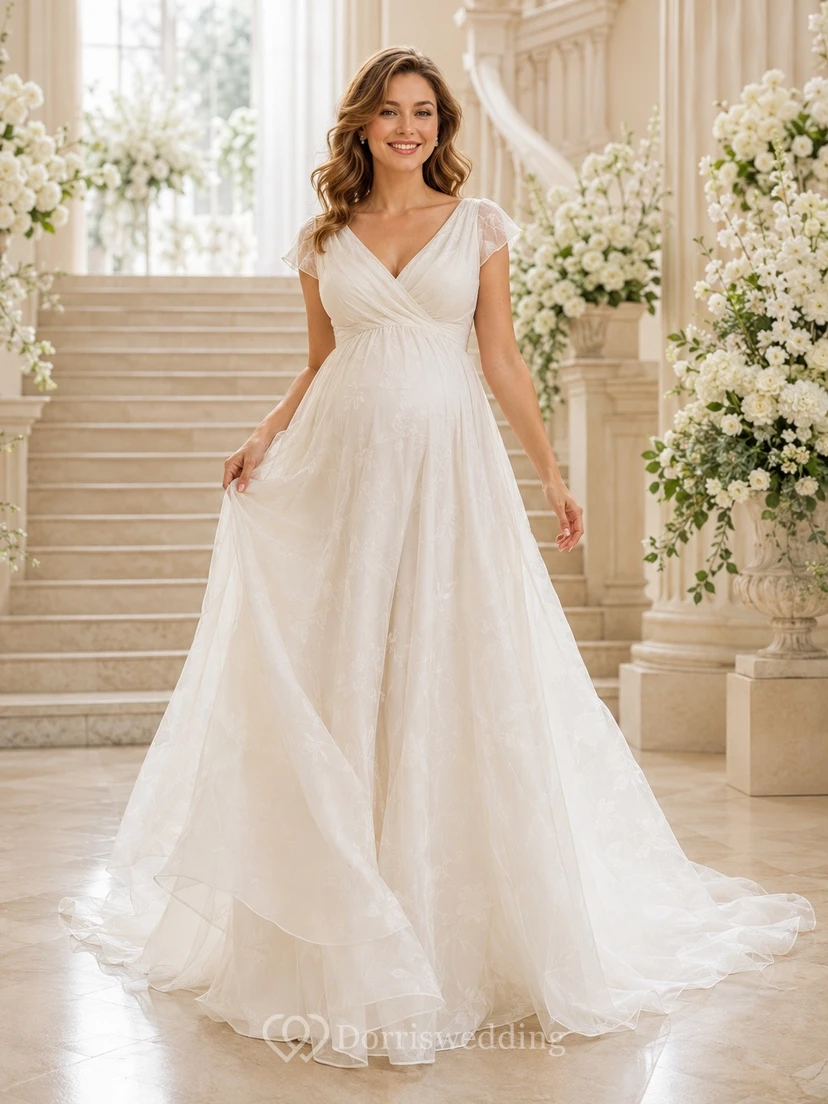 Vestido de novia sin mangas, ligero, de tul, con escote corazón, falda escalonada y cola larga.