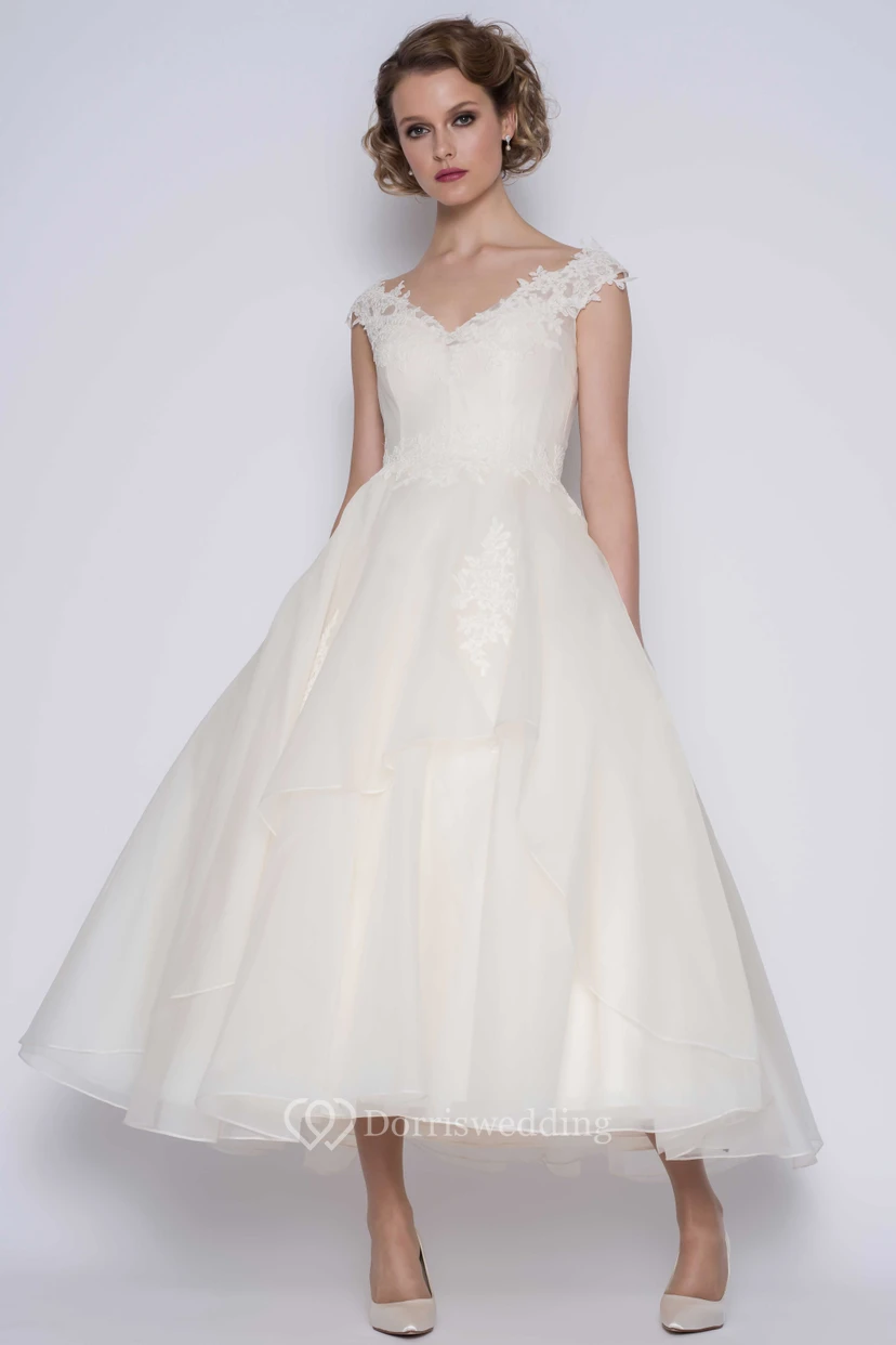 Robe de bal élégante en organza, manches courtes, longueur cheville, ornée de fleurs.