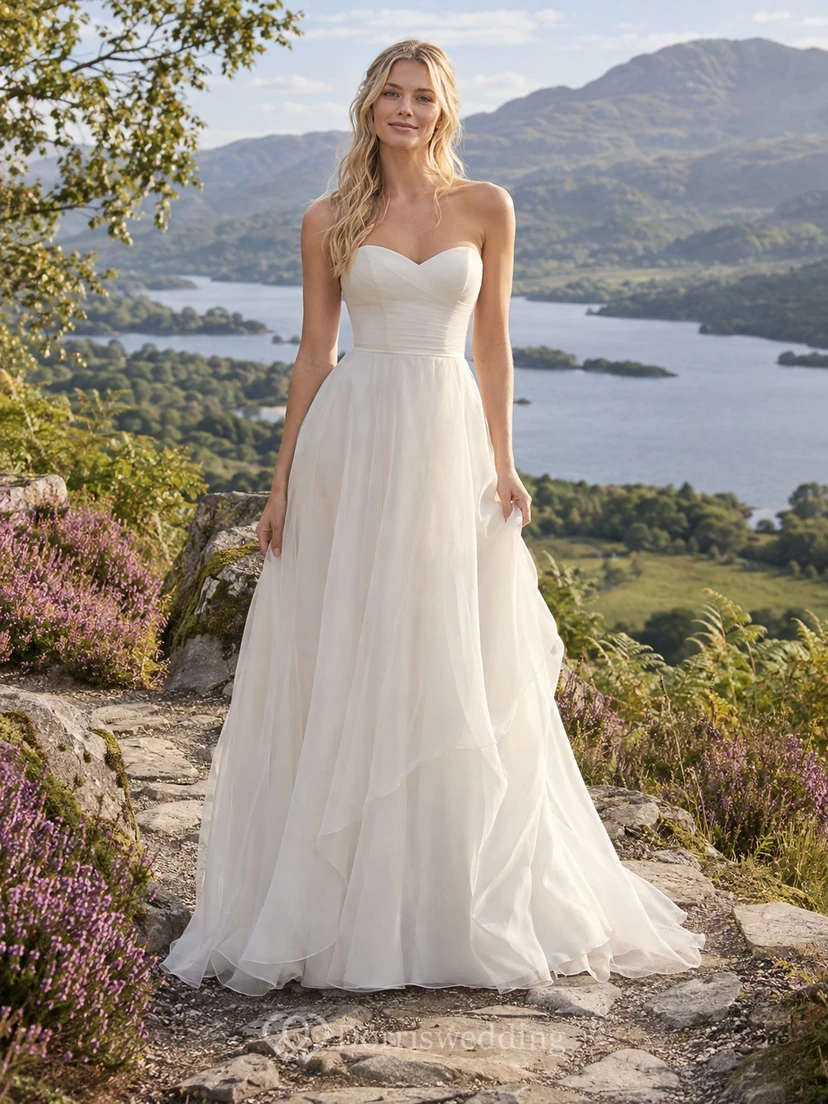 Vestido de novia sencillo de corte A con escote corazón, sin mangas, de organza y con cola.
