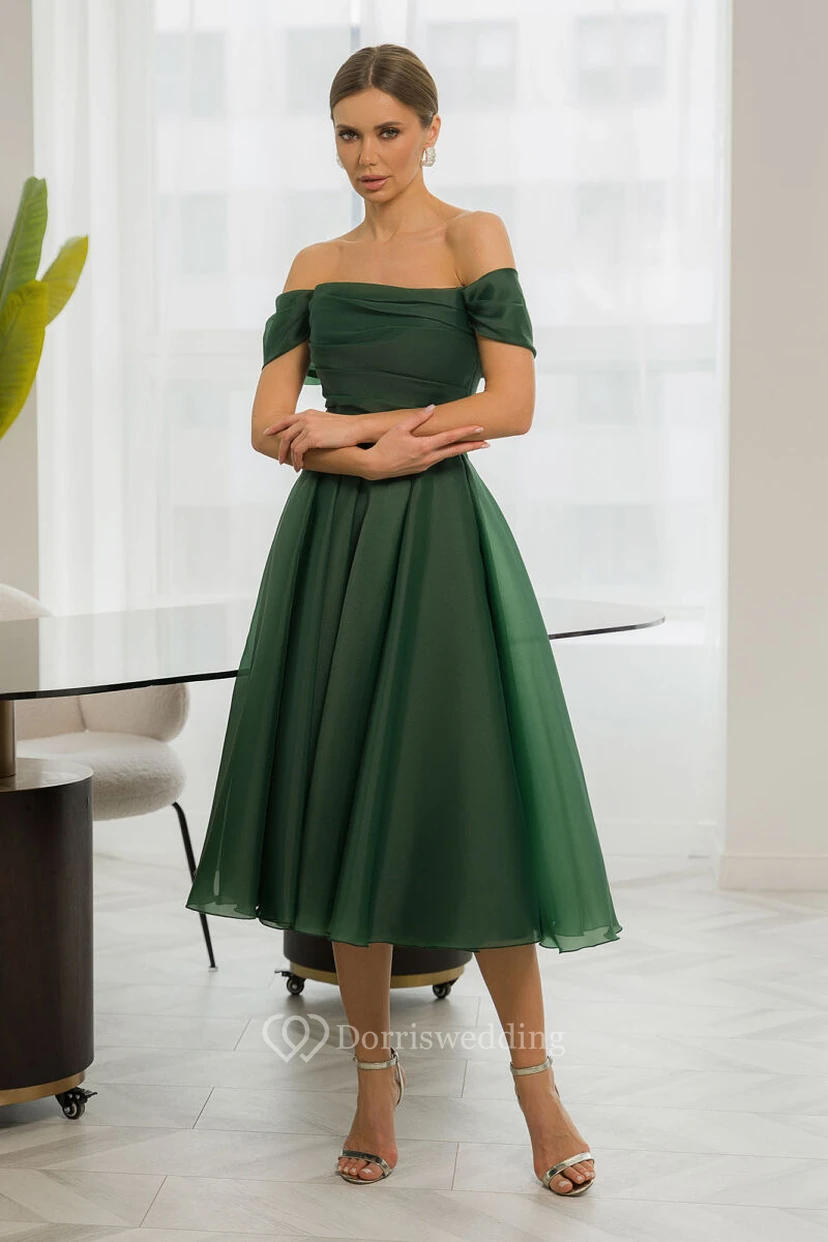 Vestido sencillo de gasa estilo imperio con hombros descubiertos y corte en A, largo hasta la rodilla.
