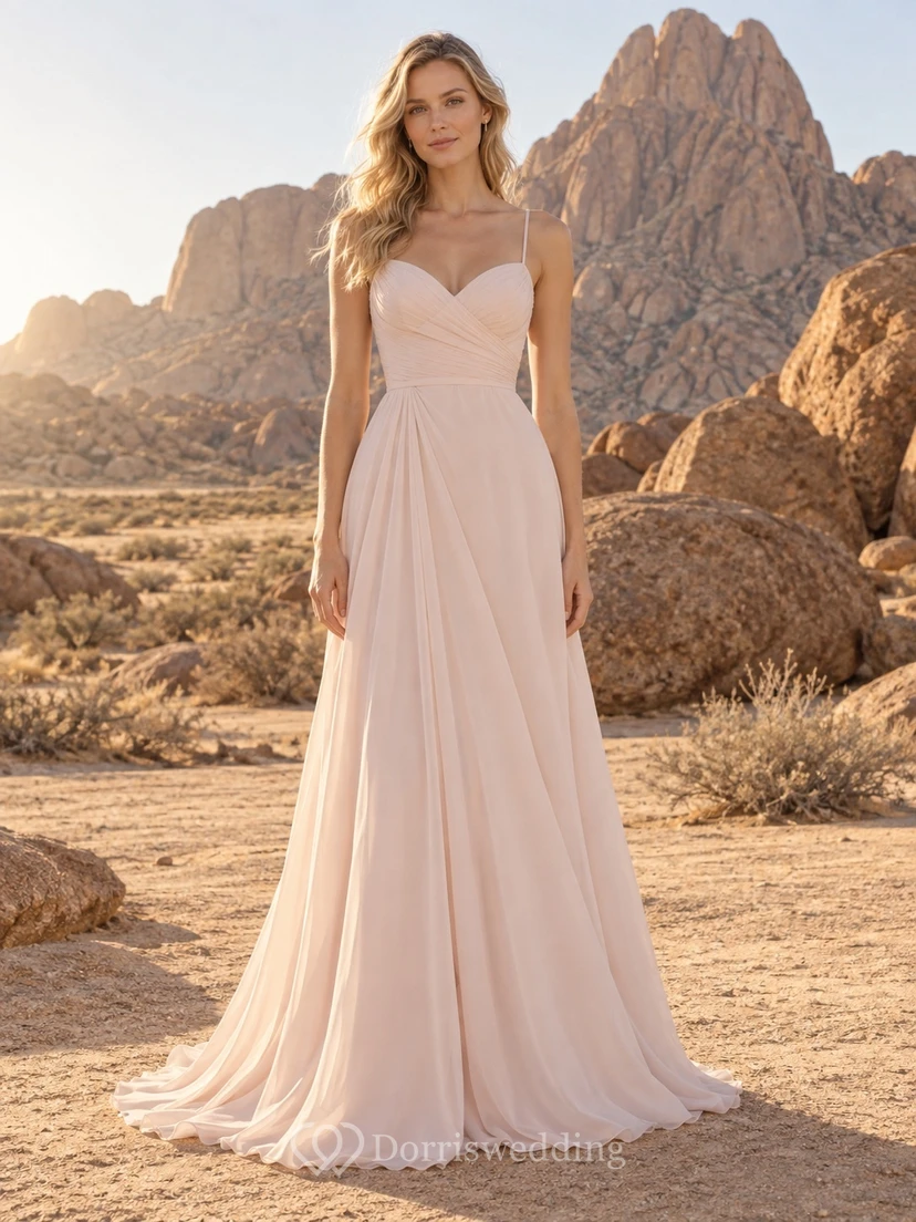 Vestido de novia sencillo de gasa rosa empolvado con tirantes finos y cola larga.