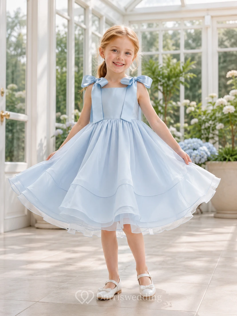 Robe de demoiselle d'honneur bleu ciel en mousseline de soie, coupe trapèze, col carré et nœud dans le dos.