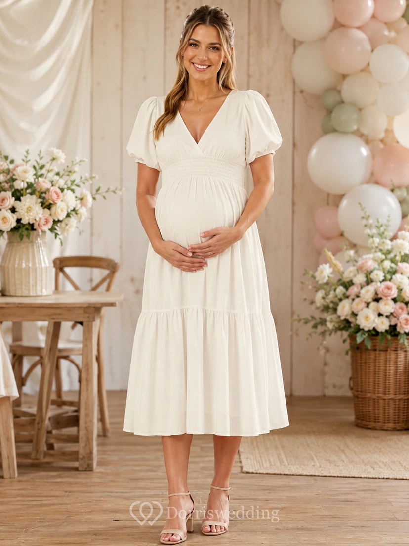 Robe de maternité empire en mousseline blanche à col V et manches bouffantes, idéale pour un thé.