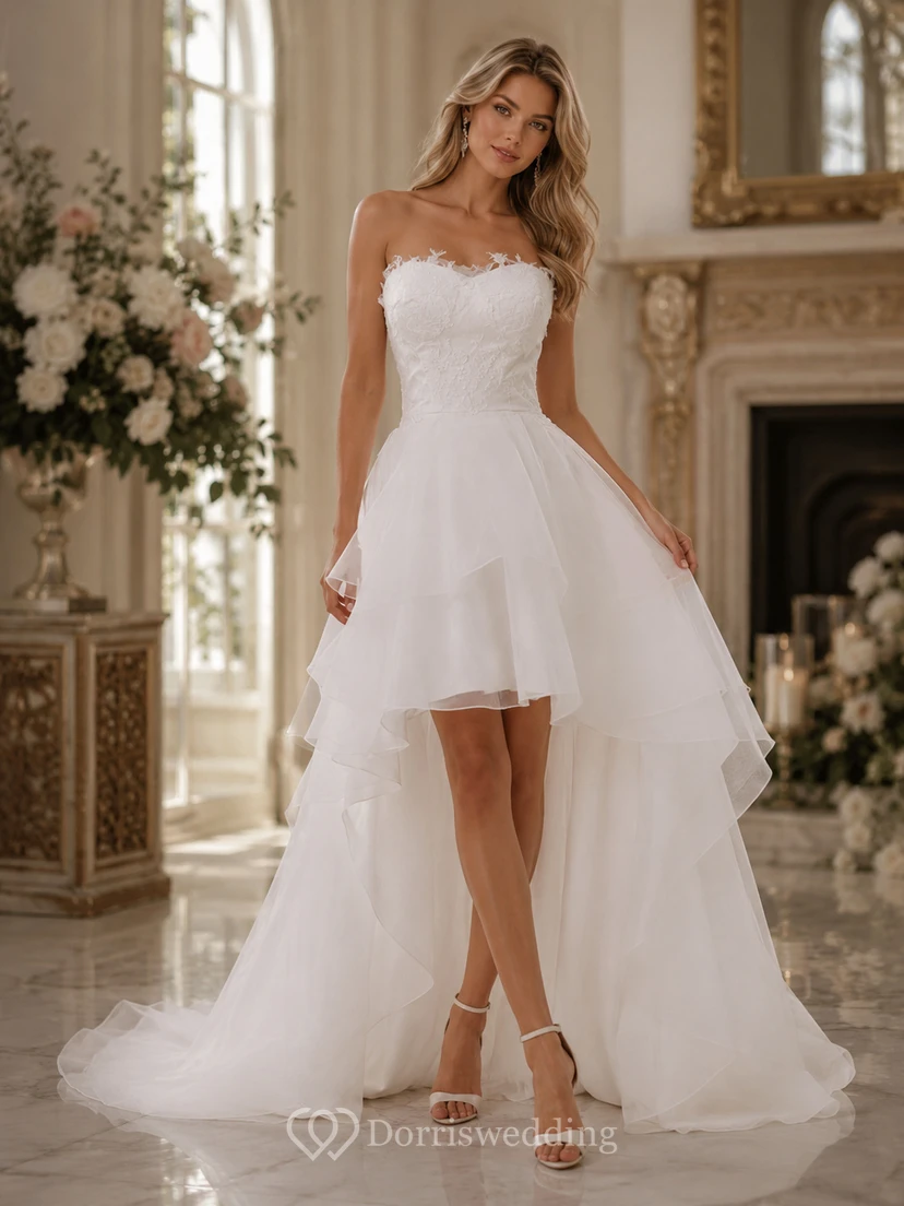 Robe de mariée en mousseline à dos lacé et décolleté asymétrique, ornée de volants et de superpositions