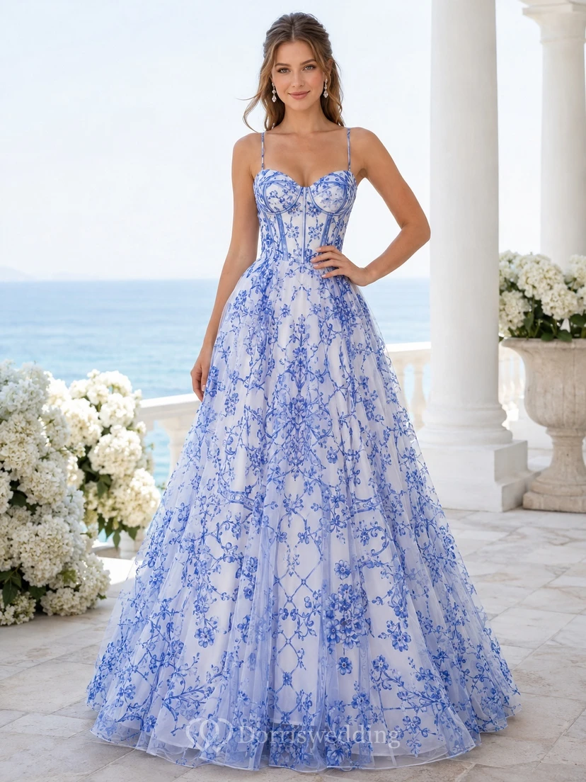Robe de bal longue en tulle à imprimé floral bleu et blanc, bustier cœur et bretelles spaghetti.