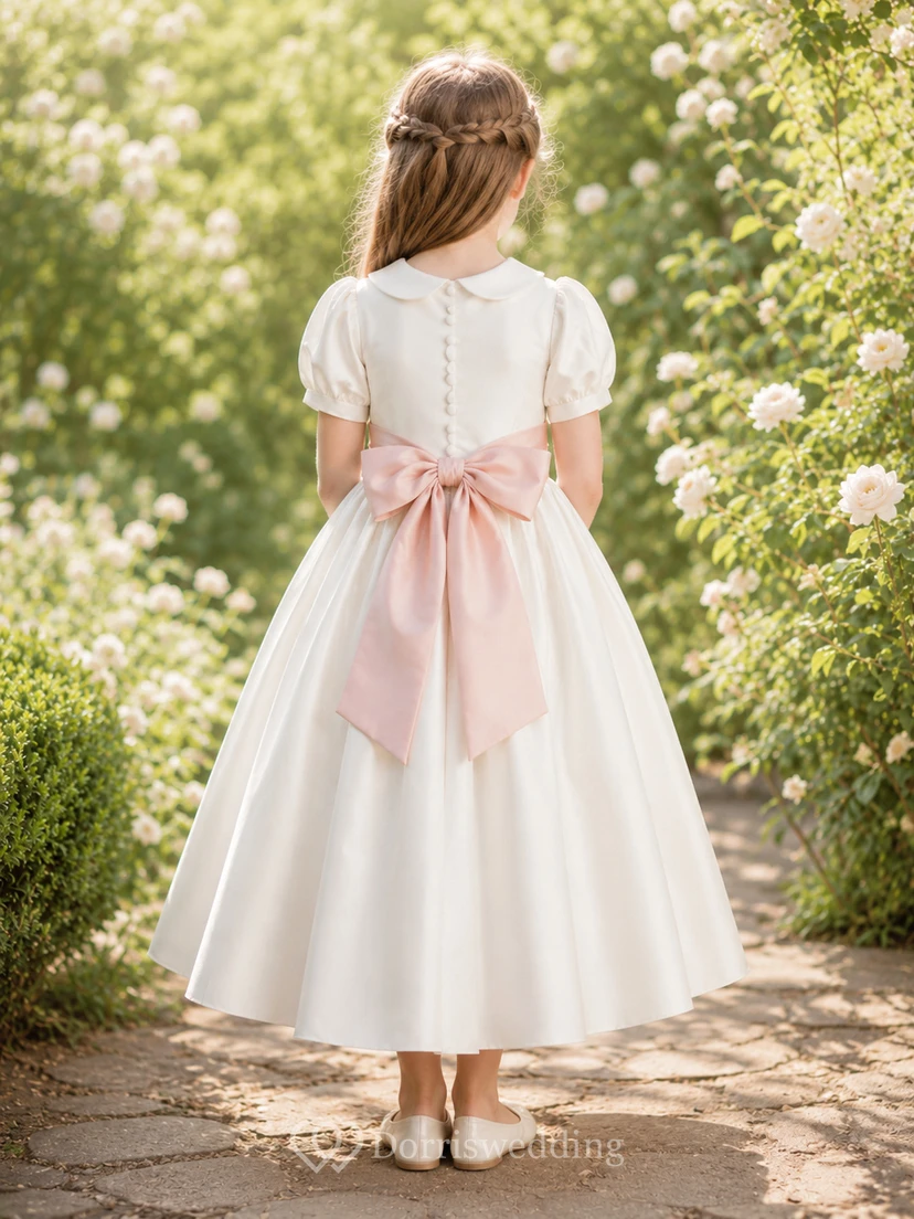 Vestido de niña de flores de satén color marfil con corte en A, mangas cortas abullonadas, escote joya y falda a la altura de la rodilla con detalles de lazos. view 2