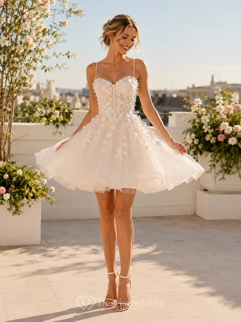 Robe de mariée mini en tulle à bretelles spaghetti et dentelle florale, décolleté cœur, style romantique.