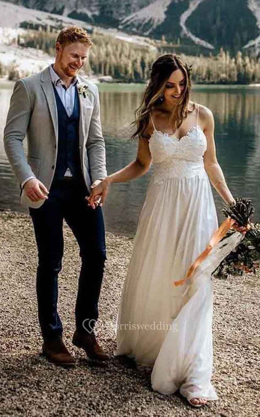 Vestido de novia de estilo imperio con encaje y tirantes finos, ideal para bodas al aire libre en el campo.