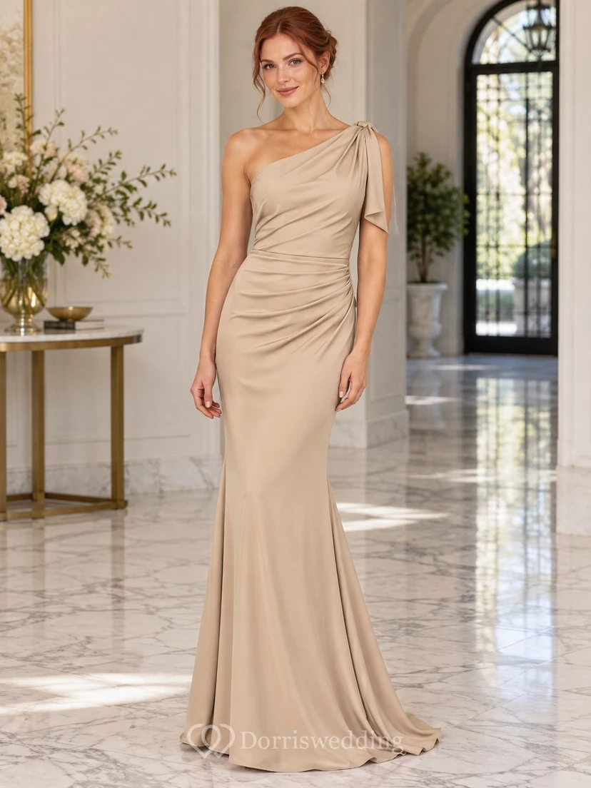 Elegante vestido de invitada largo hasta el suelo, asimétrico, de satén color topo y sin mangas.