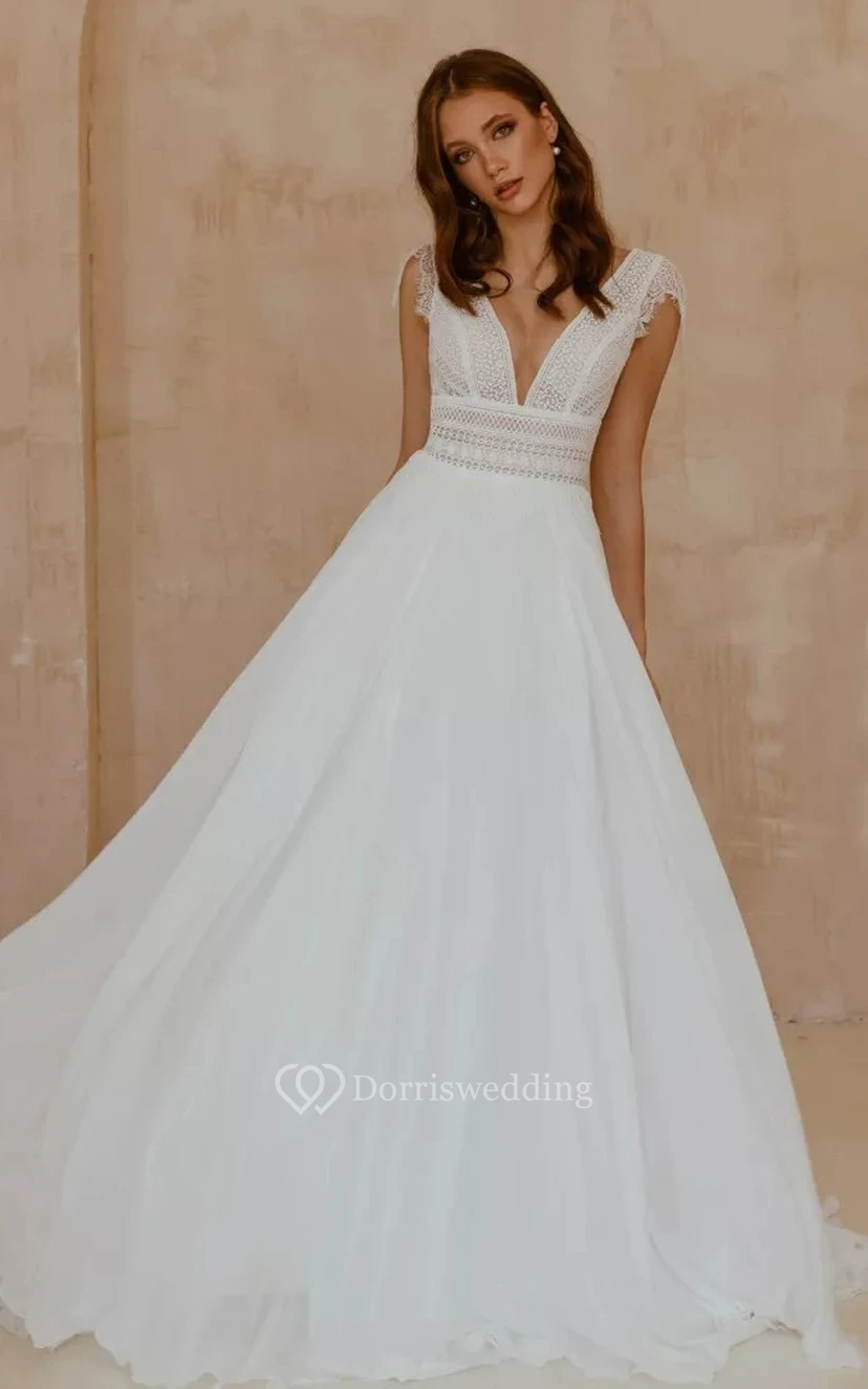 Robe de mariée bohème en mousseline de soie et dentelle, col en V, coupe trapèze, manches courtes, longueur au sol et traîne.