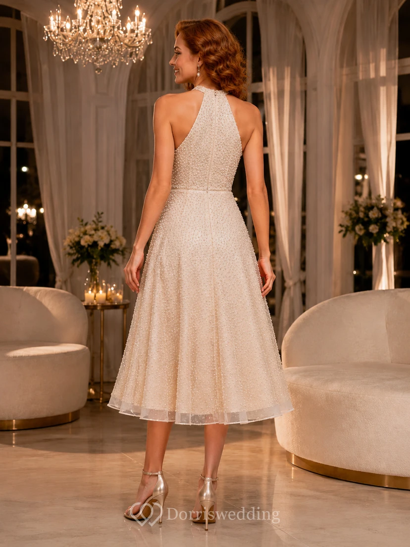 Robe de mariée champagne à col halter et coupe trapèze, longueur thé, ornée de perles, idéale pour une réception. view 2