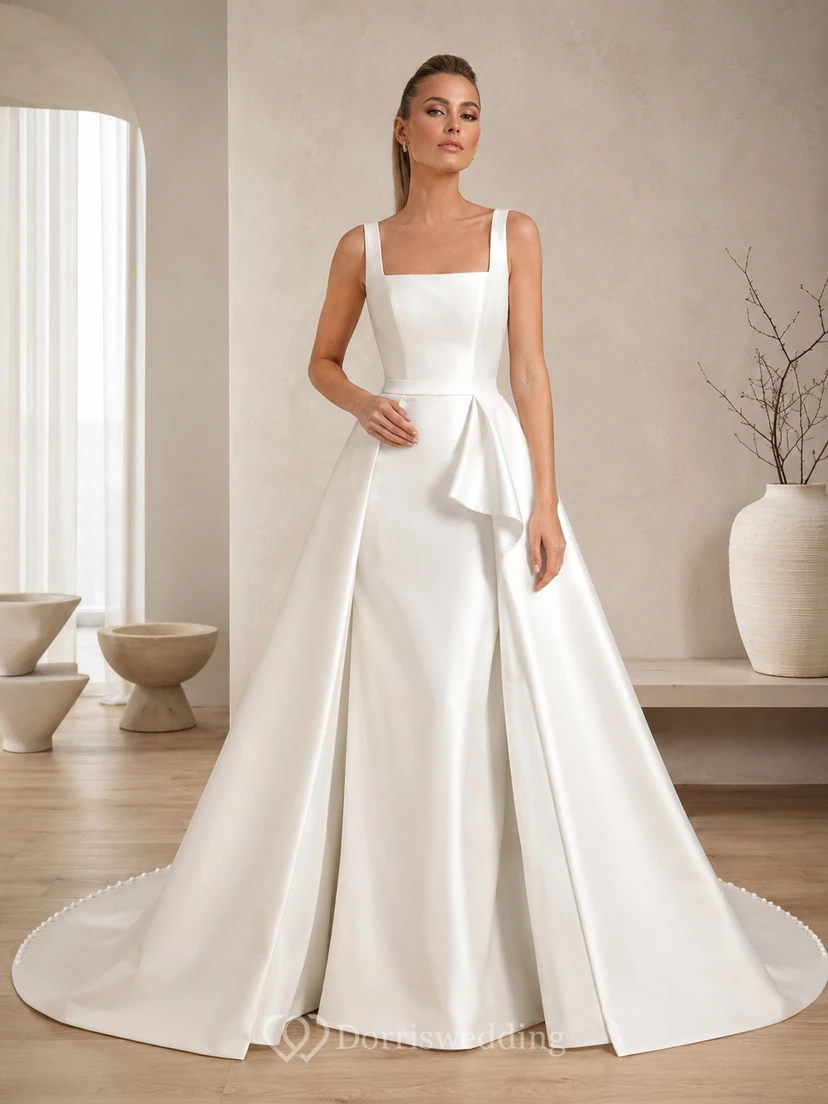 Robe de bal sans manches en satin ornée d'un col carré et d'une traîne cathédrale, ornée d'un nœud sculptural, pour un mariage de destination.