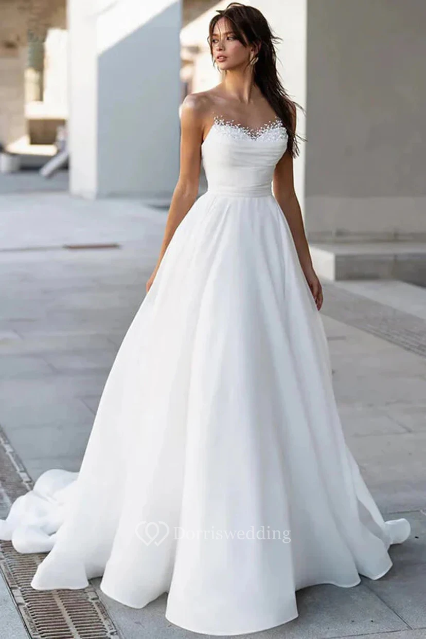 Vestido de novia de satén sin tirantes, con corte imperio y fruncido, estilo princesa, con pedrería.