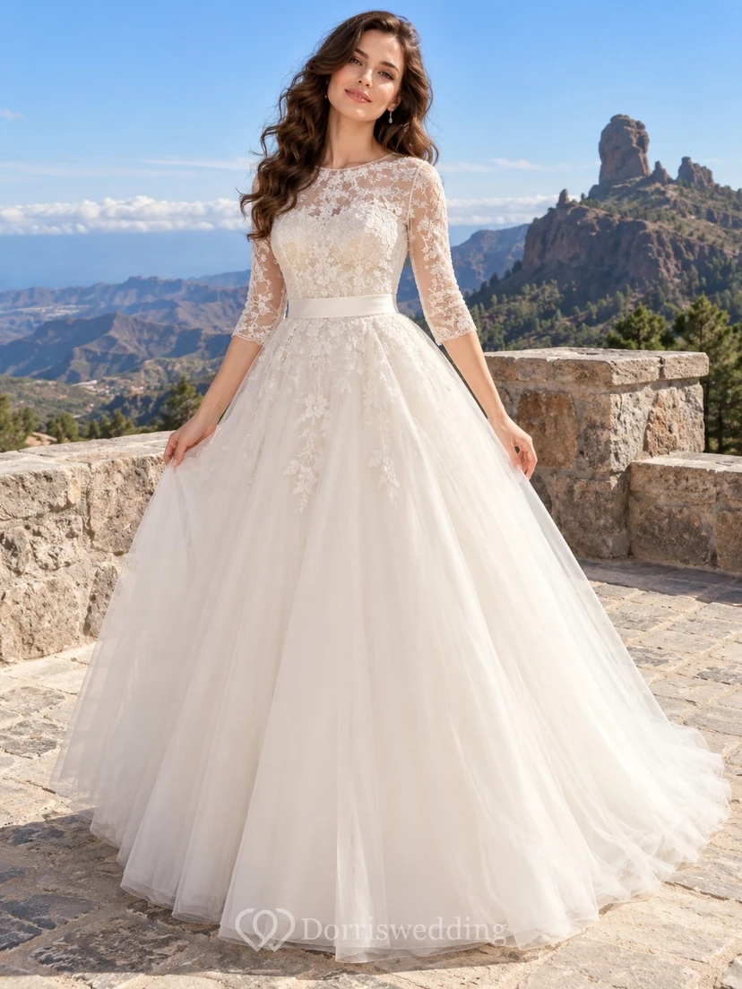 Vestido de novia romántico de gala con escote barco, mangas tres cuartos, tul, satén y encaje, con cola larga.
