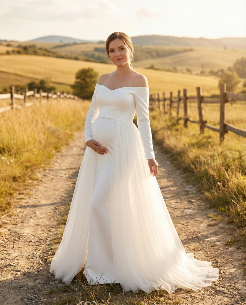 Robe de mariée de maternité à épaules dénudées et manches longues, avec surjupe en tulle et traîne.