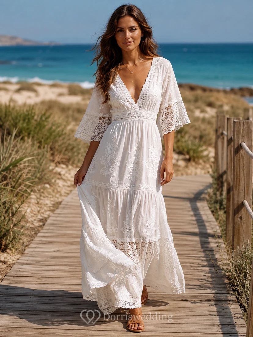 Vestido bohemio blanco de encaje de algodón ibicenco, corte A, largo hasta el suelo, escote en V, mangas acampanadas.