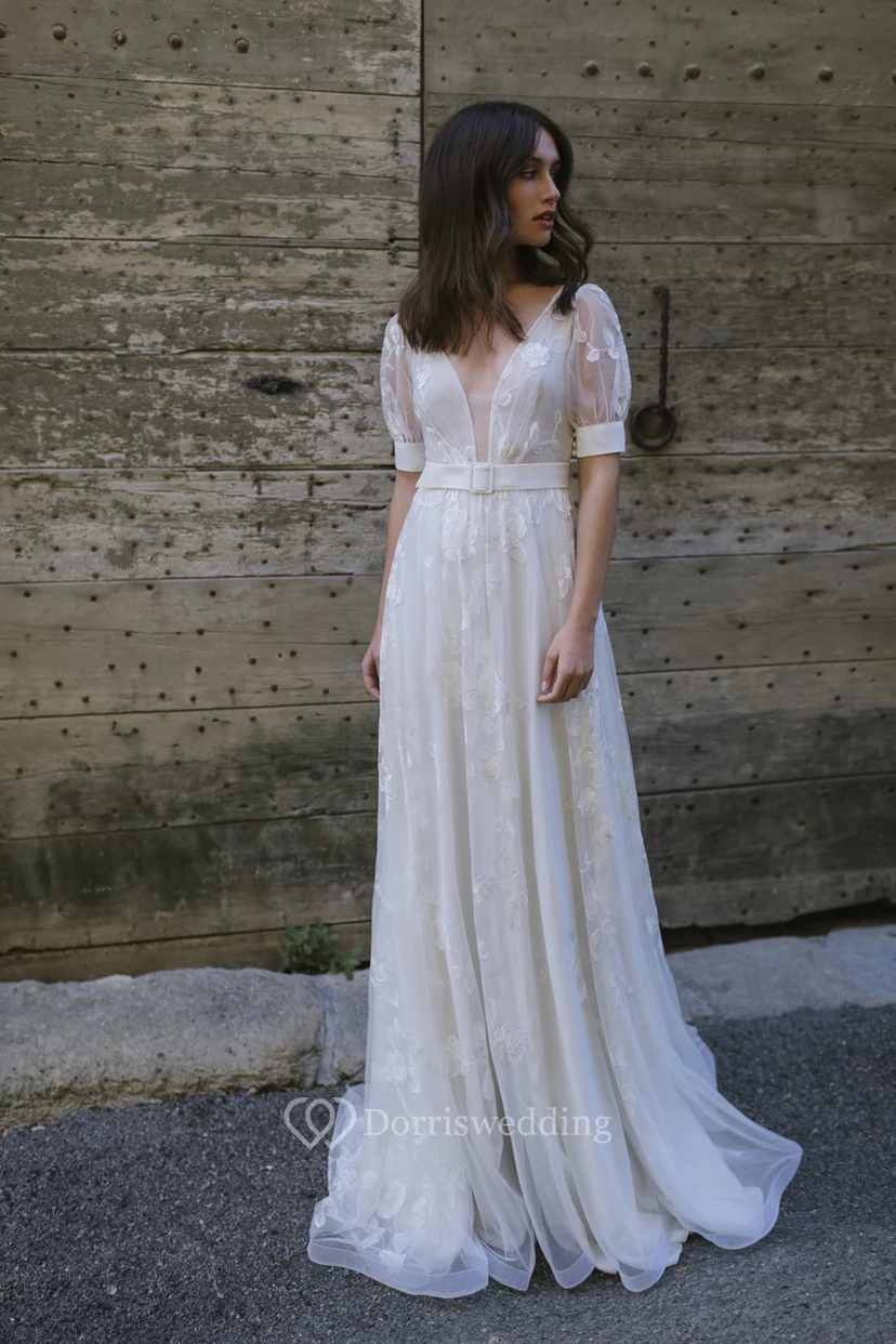 Vestido de novia largo y sexy de tul con escote pronunciado, fajín y pliegues.