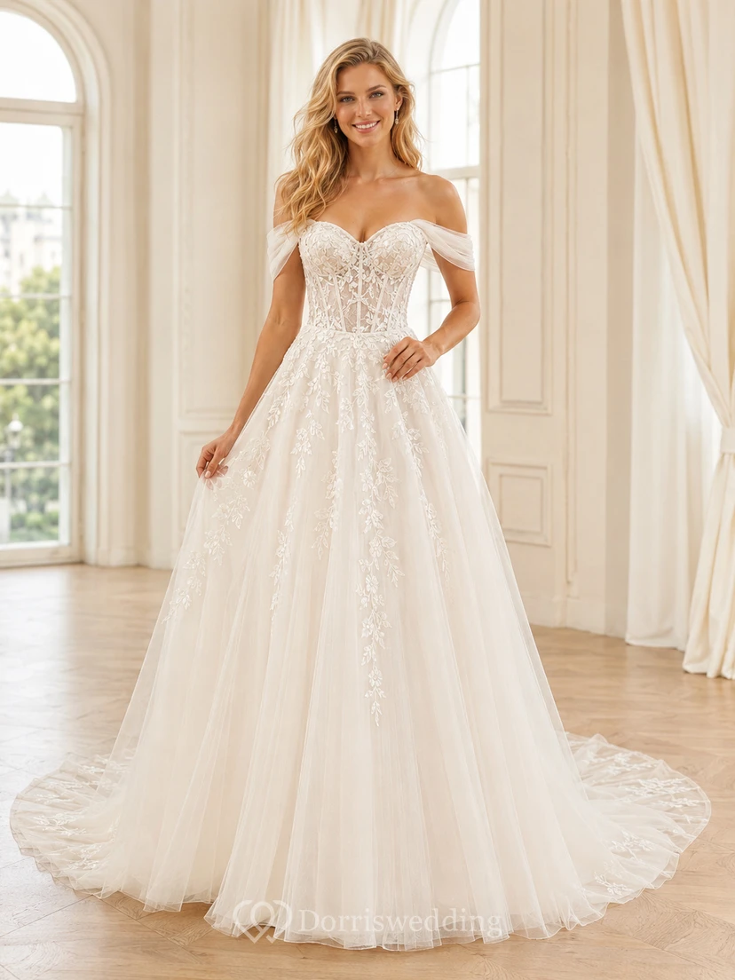 Robe de mariée champêtre en tulle et dentelle aérienne, épaules dénudées, manches courtes, coupe trapèze, traîne chapelle, ornée d'appliqués floraux.