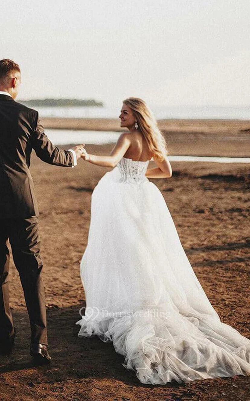 Elegantes A-Linien-Brautkleid aus Tüll mit Schnürung, Spitzenoberteil und kurzer Schleppe für die Strandhochzeit. view 2