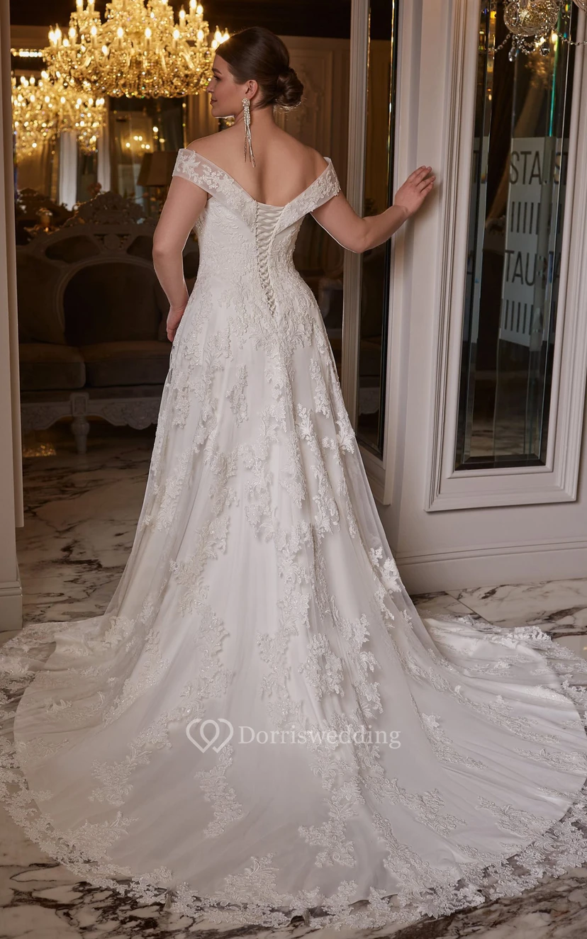 Robe de mariée élégante en dentelle, coupe trapèze, manches courtes et traîne, ornée d'appliqués view 2