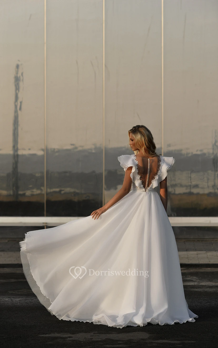 Robe de mariée vintage en mousseline de soie, manches bouffantes, traîne courte, ornée de perles et de volants, coupe bal. view 4