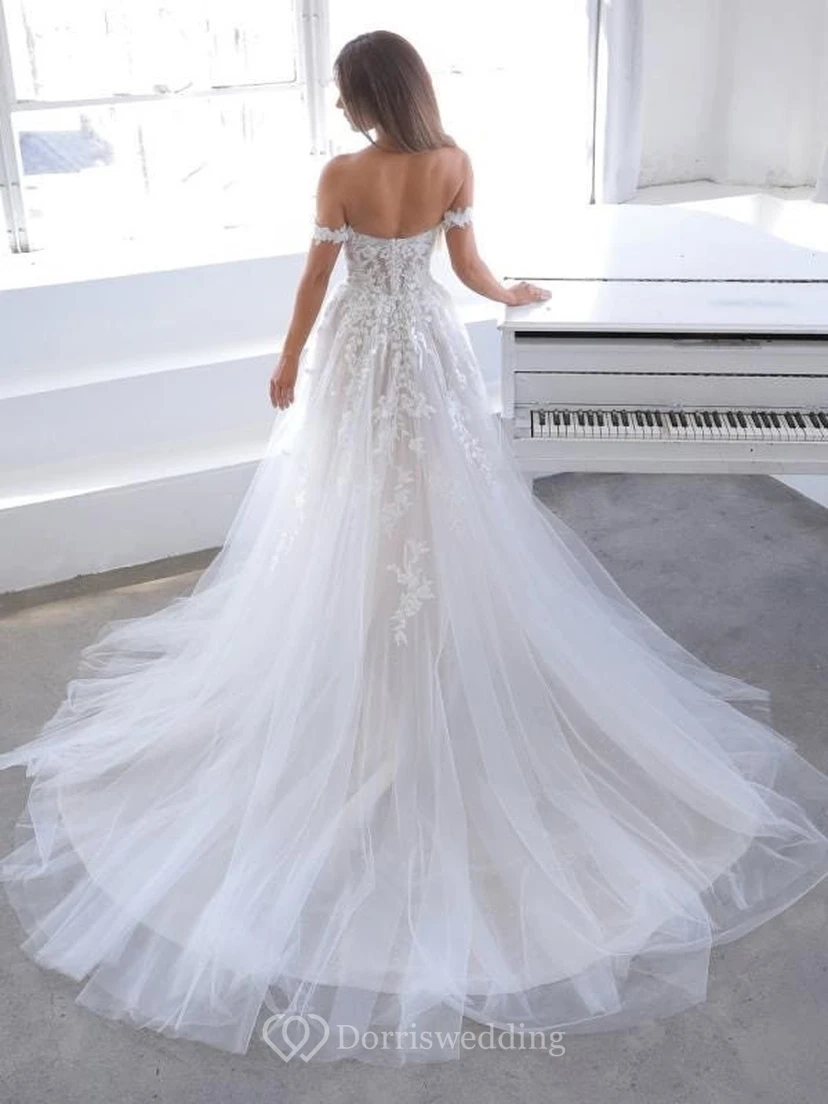 Vestido de novia etéreo de corte imperio con tul, hombros descubiertos y apliques de encaje. view 2