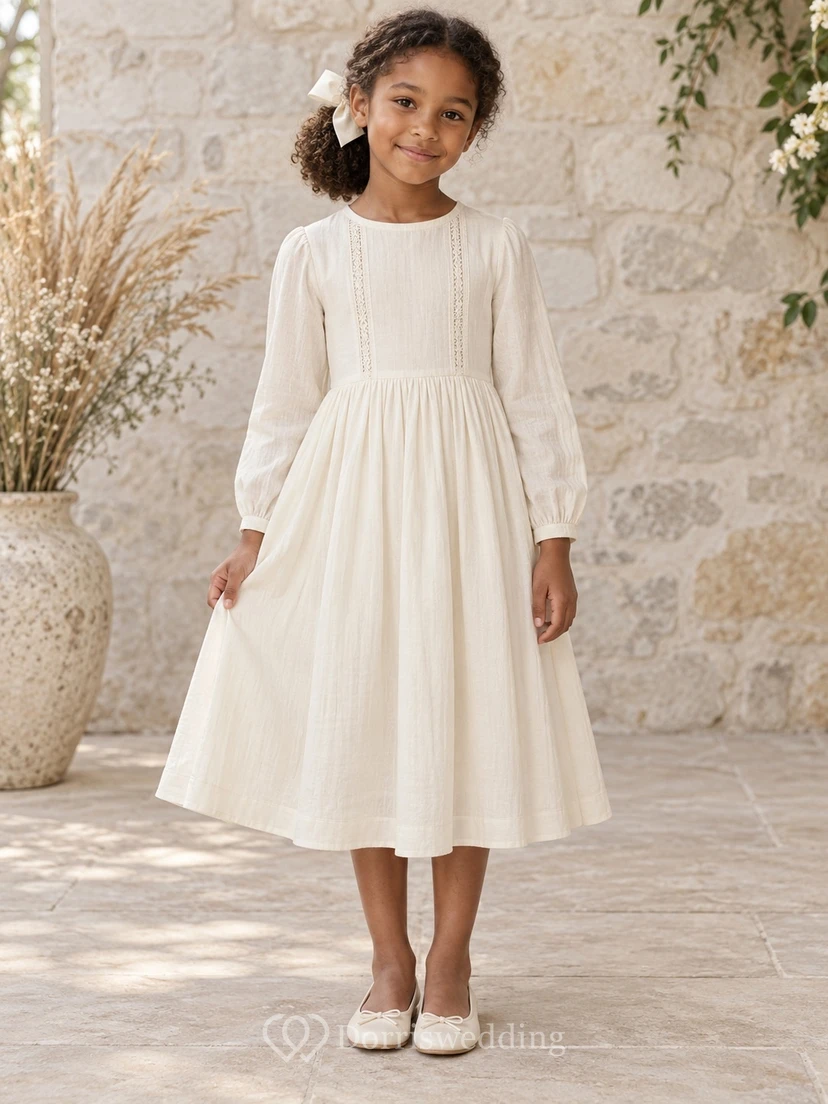 Schlichtes, dezentes, langärmeliges, cremefarbenes Blumenmädchenkleid mit zartem Spitzeneinsatz, schmalen Bündchen, gerafftem A-Linien-Schnitt und Knopfleiste am Rücken.