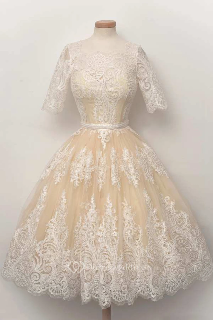 Vestido de encaje con escote redondo, corte en A y mangas cortas, con pliegues.