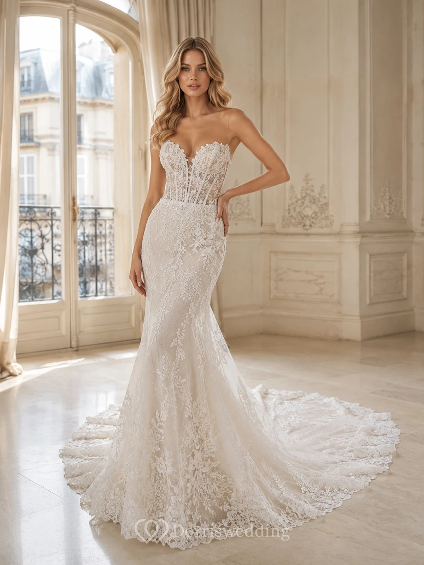 Robe de mariée sirène bustier en dentelle vaporeuse, ornée d'appliqués floraux et d'une traîne chapelle.
