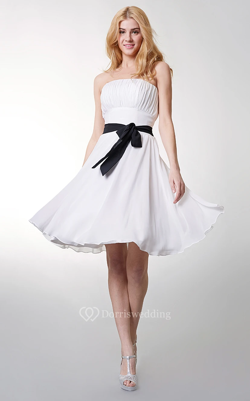 Precioso vestido corto de gasa sin tirantes con corte en A y lazo en la cintura.