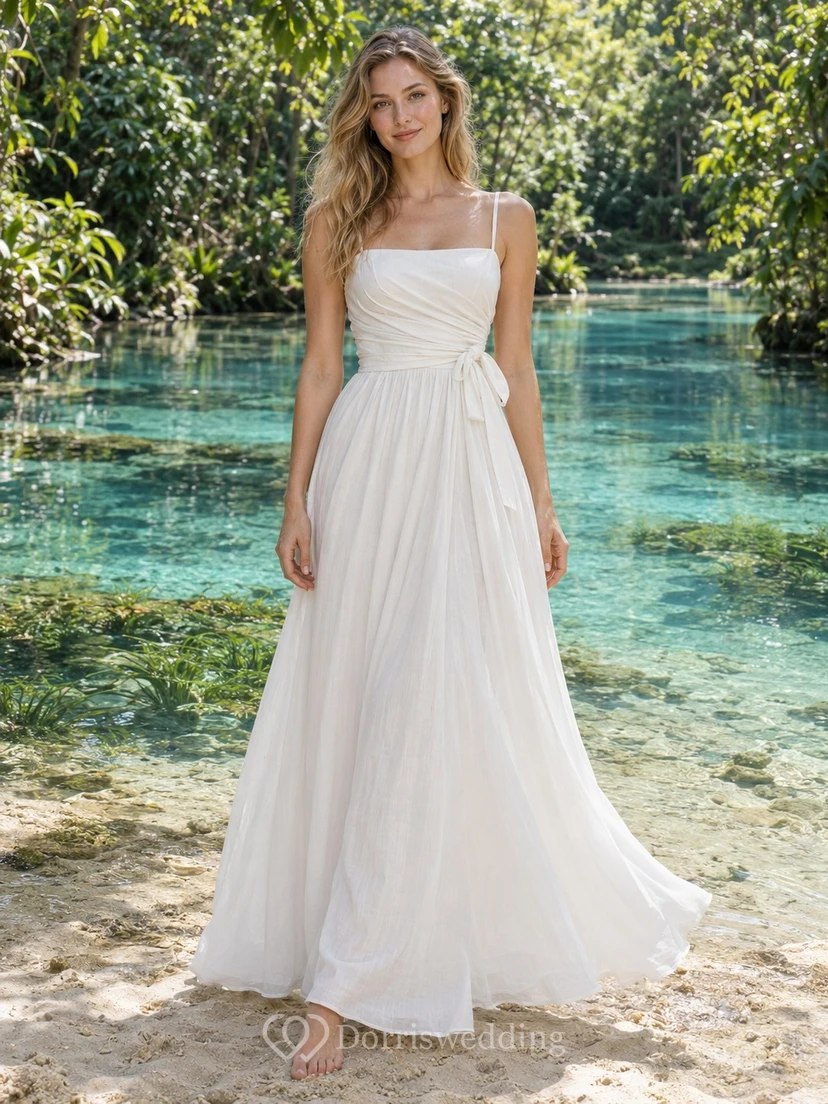Einfaches, eckiges Brautkleid aus Baumwollvoile mit Trägern und seitlichem Bindeband am Rock.