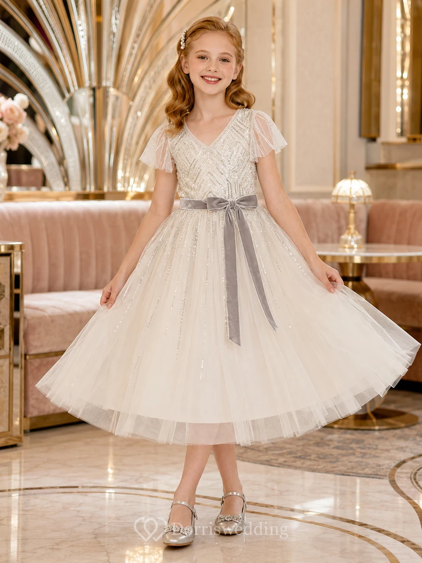 Vestido de niña de flores color marfil, largo hasta la rodilla, tul con lentejuelas, corte en A, escote en V, mangas con volantes, abalorios geométricos plateados, lazo de terciopelo gris.