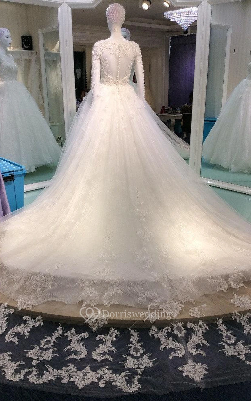 Vestido largo de manga larga con encaje y cuentas, corte en A y espalda transparente.