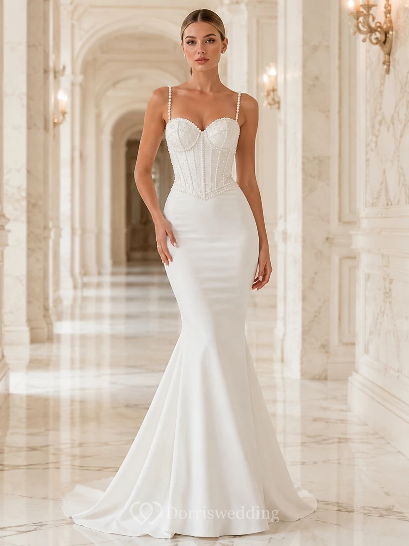 Vestido de novia de satén sin mangas con escote corazón y cola larga, adornado con perlas.