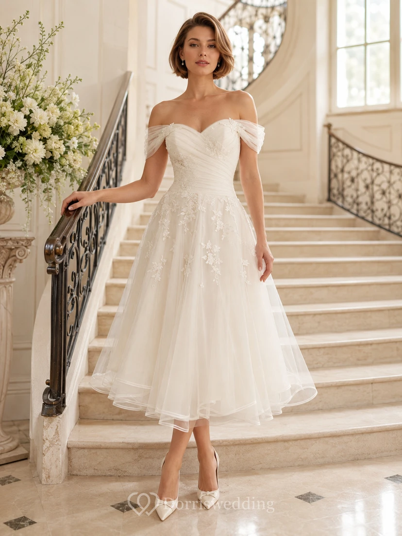 Elegante vestido de novia romántico de tul con mangas cortas y hombros descubiertos hasta la rodilla.