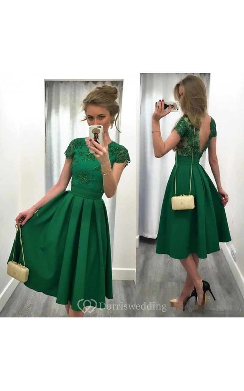 Robe de soirée mi-longue à dos nu et coupe trapèze, ornée d'appliqués et d'un décolleté en V.