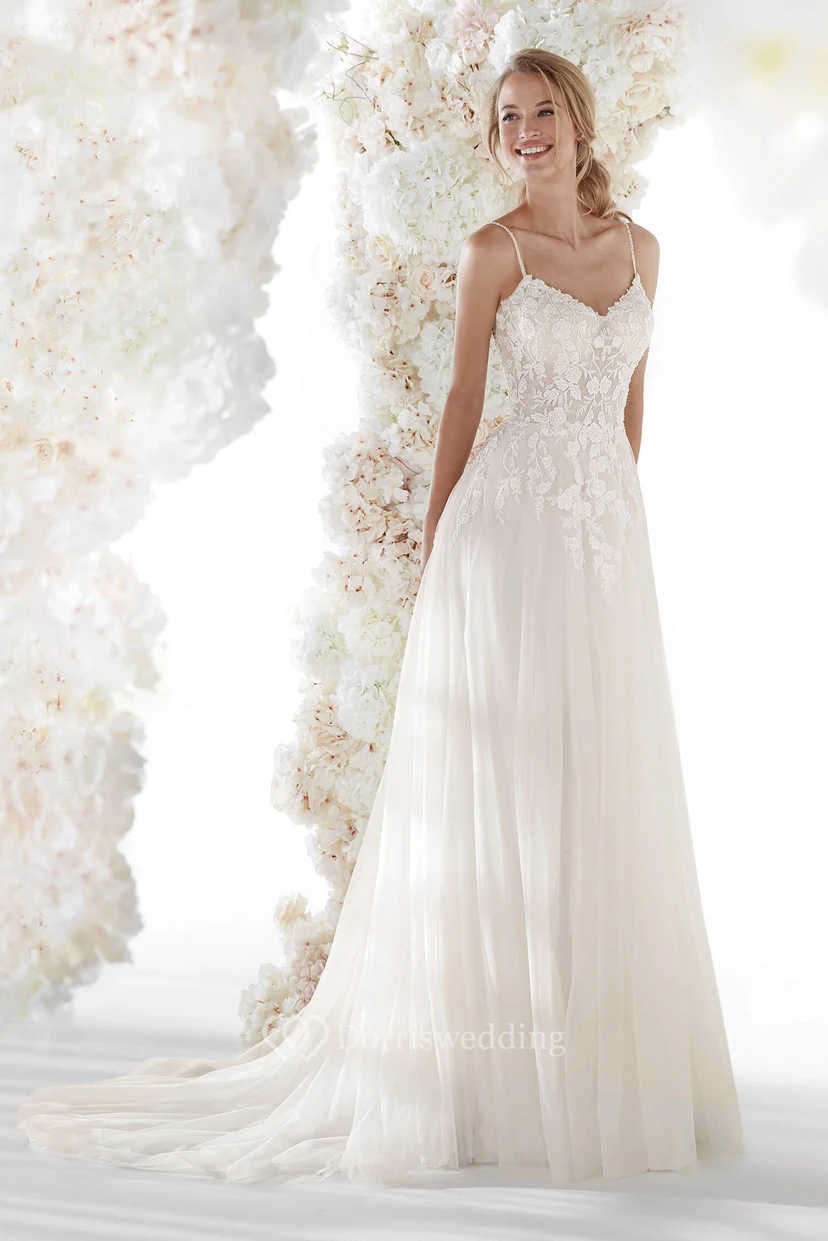 Robe de mariée vaporeuse et simple en tulle, dos nu, bretelles spaghetti, appliques de dentelle et fronces.