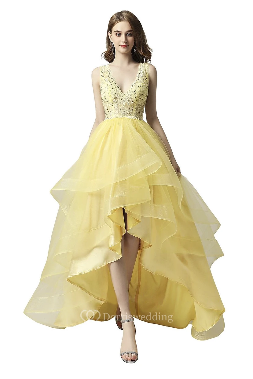 Adorable robe sans manches asymétrique ornée de perles, de volants en cascade et d'une encolure en forme de goutte.
