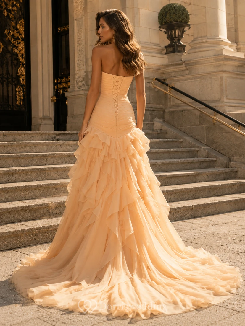 Vestido de fiesta de tul color champán, sin tirantes, con escote corazón, corte sirena, cola larga, volantes y capas. view 2