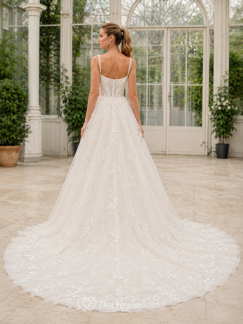 Robe de mariée traditionnelle en dentelle et tulle, col carré, sans manches, coupe trapèze, traîne chapelle, applications florales, idéale pour un mariage à destination. view 2