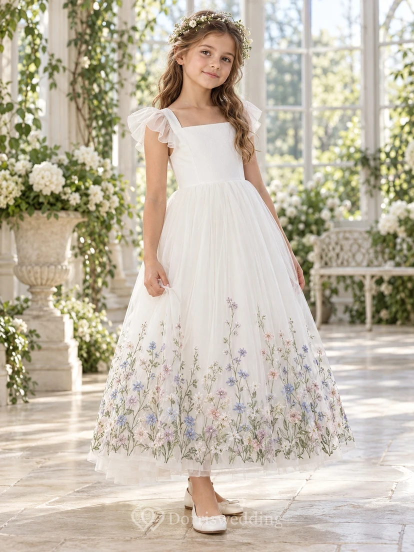 Vestido de niña de flores de tul color marfil, corte en A, largo hasta los tobillos, mangas con volantes y dobladillo bordado con motivos botánicos.